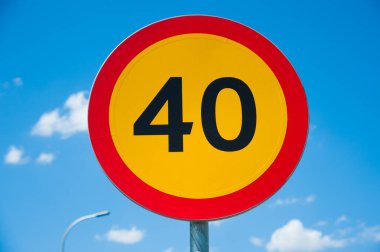 Yol işareti: hız limiti 40 km / saat. Mavi gökyüzüne karşı yol işareti.