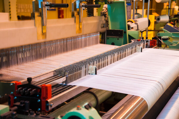 Industrial fabric production line. Weaving looms at a textile factory