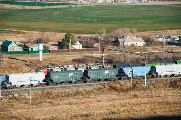 Freight train crossing through railroad station. Railway freight cars and tank cars