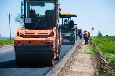 Yol yapımı, sanayi ve takım çalışması üzerine çalışan işçiler, yeni asfalt