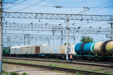 Yük treni tren istasyonundan geçiyor. Demiryolu yük vagonları ve tank vagonları