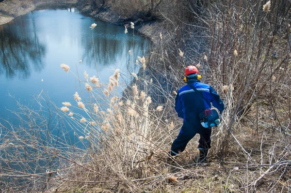 Człowiek Kosi Suchej Trawy Podczas Wiosennych Porządków Terytorium Parku — Zdjęcie stockowe
