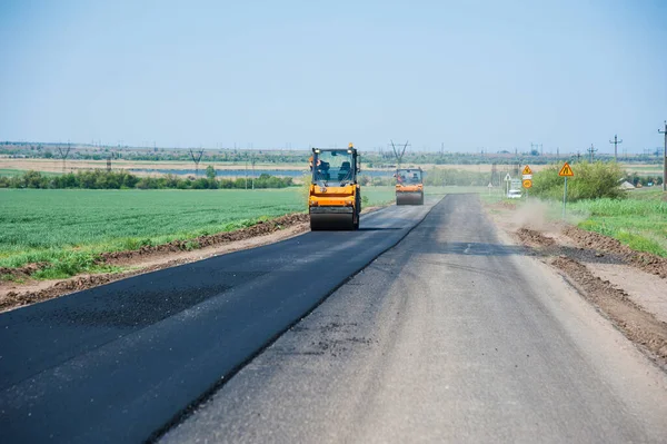 Yol yapımı, sanayi ve takım çalışması üzerine çalışan işçiler, yeni asfalt