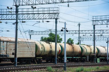 Yük treni tren istasyonundan geçiyor. Demiryolu yük vagonları ve tank vagonları