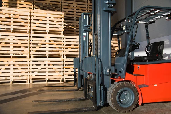 Forklift in a large warehouse for vegetable storage. Folded empty wooden boxes in warehouses, boxes are designed for harvesting fruits and vegetables