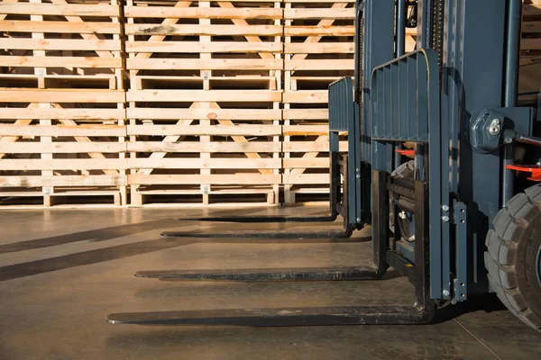 Forklift in a large warehouse for vegetable storage. Folded empty wooden boxes in warehouses, boxes are designed for harvesting fruits and vegetables