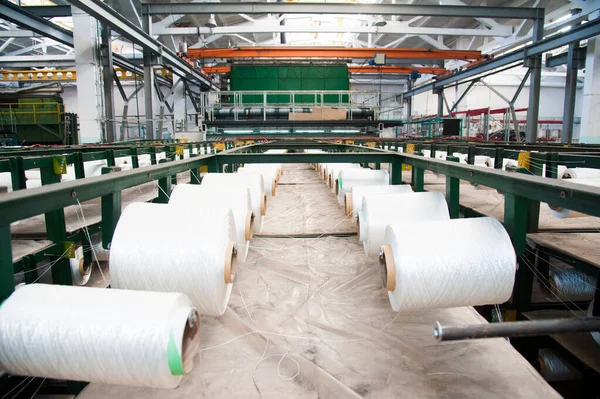 Textile industry - yarn spools on spinning machine in a textile factory