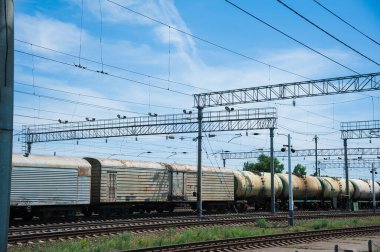 Yük treni tren istasyonundan geçiyor. Demiryolu yük vagonları ve tank vagonları