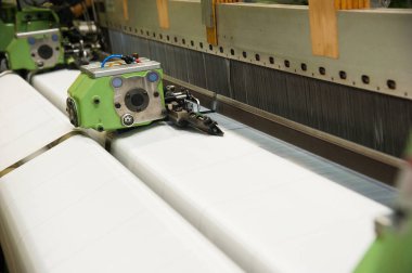 Endüstriyel kumaş üretim hattı. Bir tekstil fabrikasında dokuma tezgahı