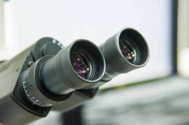 Laboratuvarda metal mercekle mikroskobun yakın çekim görüntüsü.