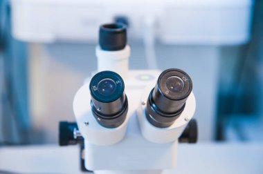 Laboratuvarda metal mercekle mikroskobun yakın çekim görüntüsü.