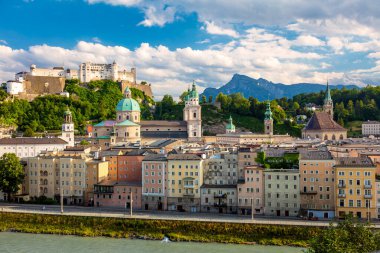 Tarihi Salzburg şehrinin güzel panoramik manzarası. Güneşli bir günde, mavi gökyüzü ve yazın bulutları olan ünlü Hohensalzburg Kalesi. Avusturya