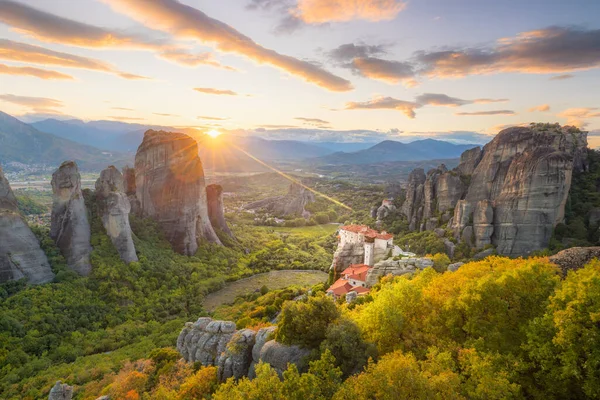 Meteora, Yunanistan 'ın gerçek güneş ve günbatımı gökyüzü ile romantik günbatımında manzarası. Meteora - inanılmaz kum taşı oluşumları. Meteora bölgesi UNESCO Dünya Mirası 'nda yer almaktadır.