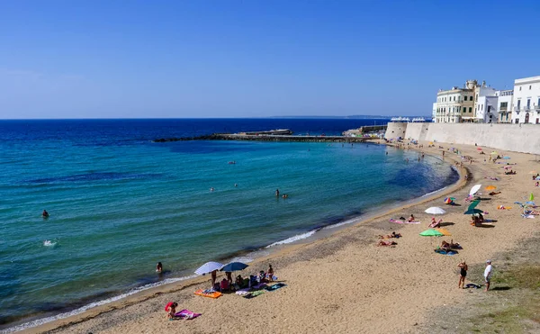 Akdeniz kıyısındaki derin mavi denizde güneşlenen insanlar.