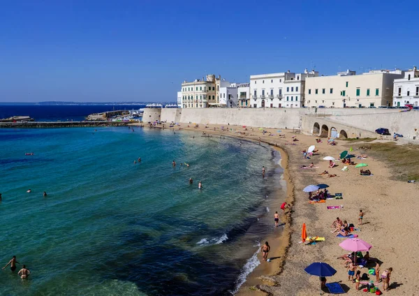 Akdeniz kıyısındaki derin mavi denizde güneşlenen insanlar.
