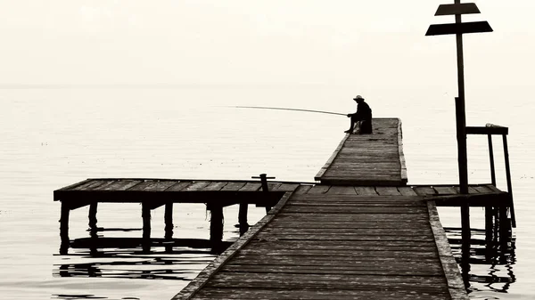 Fisherman on the old bridge. photo — Stock Photo, Image