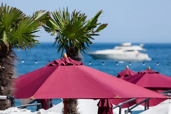 Пляжні парасольки з яхтою — стокове фото