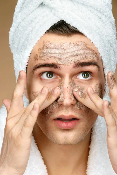 Handsome man cleans face scrub on skin