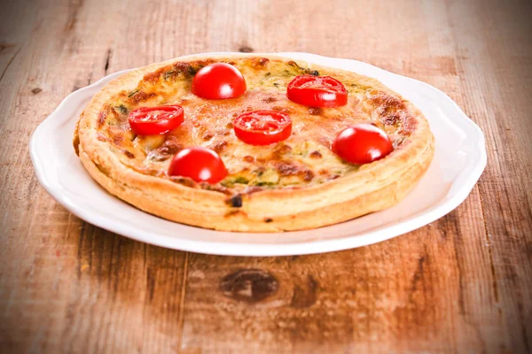 Leek and tomato quiche on white dish. — Stock Photo, Image