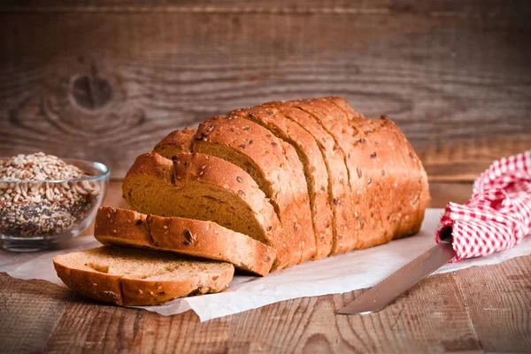 Teljes kiőrlésű kenyér, a papír sütés. — Stock Fotó