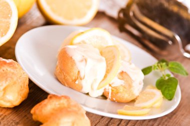 Beyaz çanak üzerinde limon profiterol. 