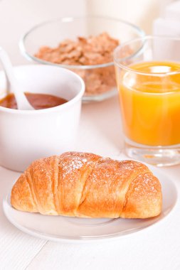 Beyaz çanak üzerinde kruvasan ile Kahvaltı.