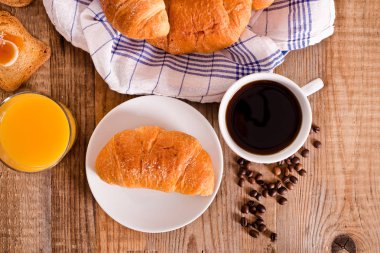 Beyaz çanak üzerinde kruvasan ile Kahvaltı.
