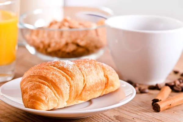Frühstück mit Croissant auf weißem Teller. — Stockfoto