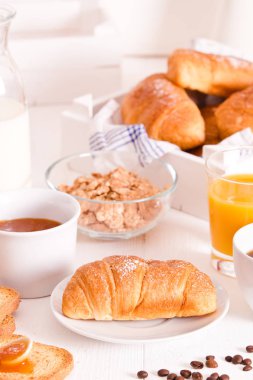 Beyaz çanak üzerinde kruvasan ile Kahvaltı. 
