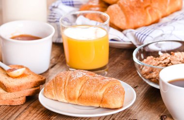 Beyaz çanak üzerinde kruvasan ile Kahvaltı. 