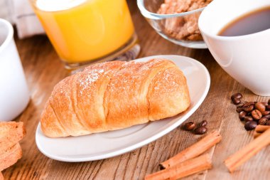 Beyaz çanak üzerinde kruvasan ile Kahvaltı. 