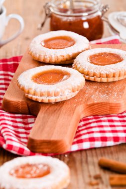 Ahşap masa üzerinde reçelli kahvaltı çerezleri.