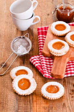 Ahşap masa üzerinde reçelli kahvaltı çerezleri.