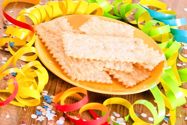 Pasticceria di Carnevale con coriandoli su piatto giallo . — Foto Stock