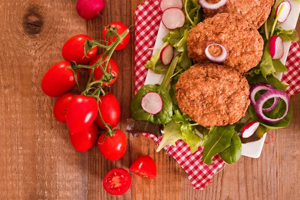 Frikadellen mit Salat auf Holztisch. — Stockfoto