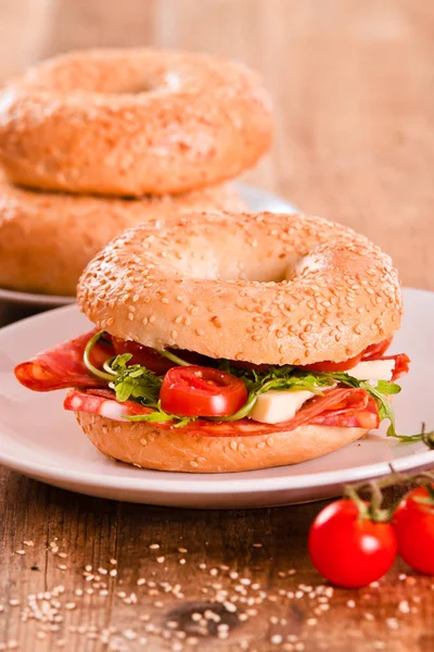 Sesame bagels with pepperoni and tomato. — Stock Photo, Image