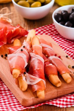 Grisini breadsticks jambon ve zeytin ahşap tablo.