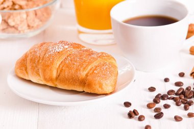 Beyaz çanak üzerinde kruvasan ile Kahvaltı. 