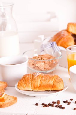 Beyaz çanak üzerinde kruvasan ile Kahvaltı. 