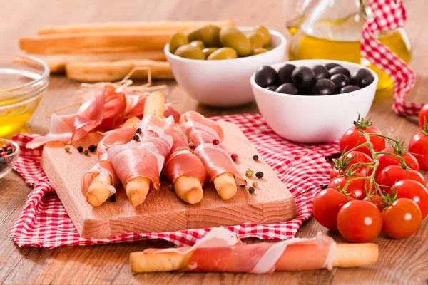 Grissini breadsticks with ham. — Stock Photo, Image