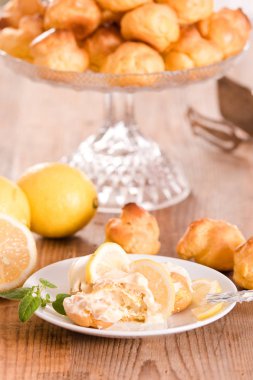 Beyaz çanak üzerinde limon profiterol.