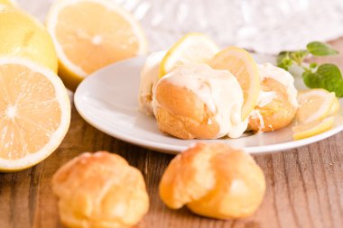 Beyaz çanak üzerinde limon profiterol.