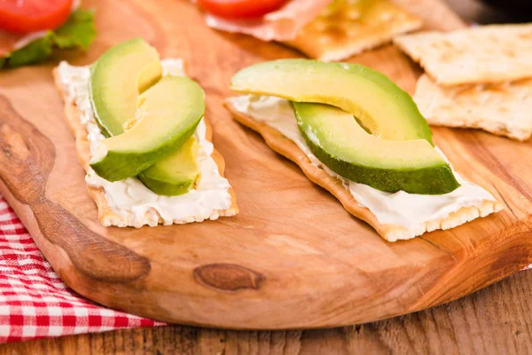 Kraker jambon ve avokado cuttingboard üzerinde.