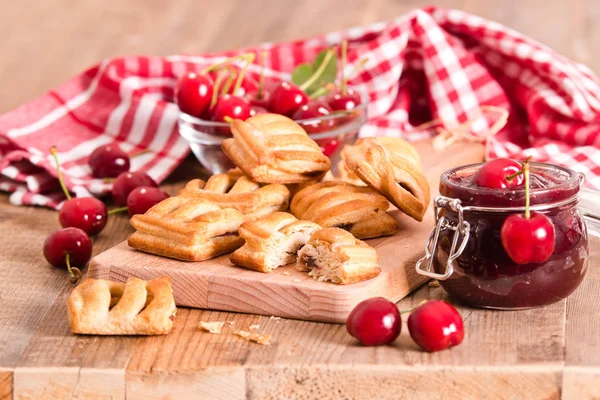 Cherry pastry pies on cuttingboard. — Stock Photo, Image