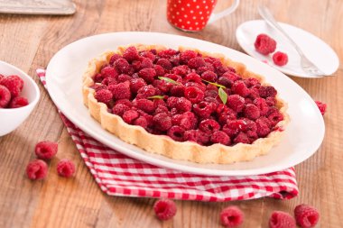 Beyaz çanak üzerinde ahududulu tart.