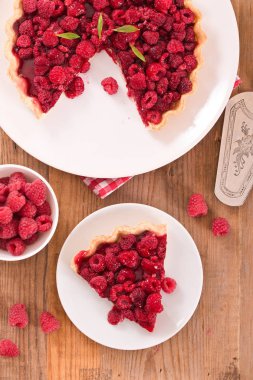 Beyaz çanak üzerinde ahududulu tart.