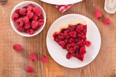 Beyaz çanak üzerinde ahududulu tart.