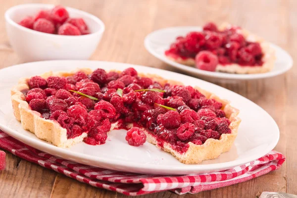 Beyaz çanak üzerinde ahududulu tart.