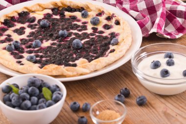 Beyaz çanak üzerinde üzümlü tart. 