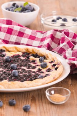 Beyaz çanak üzerinde üzümlü tart. 